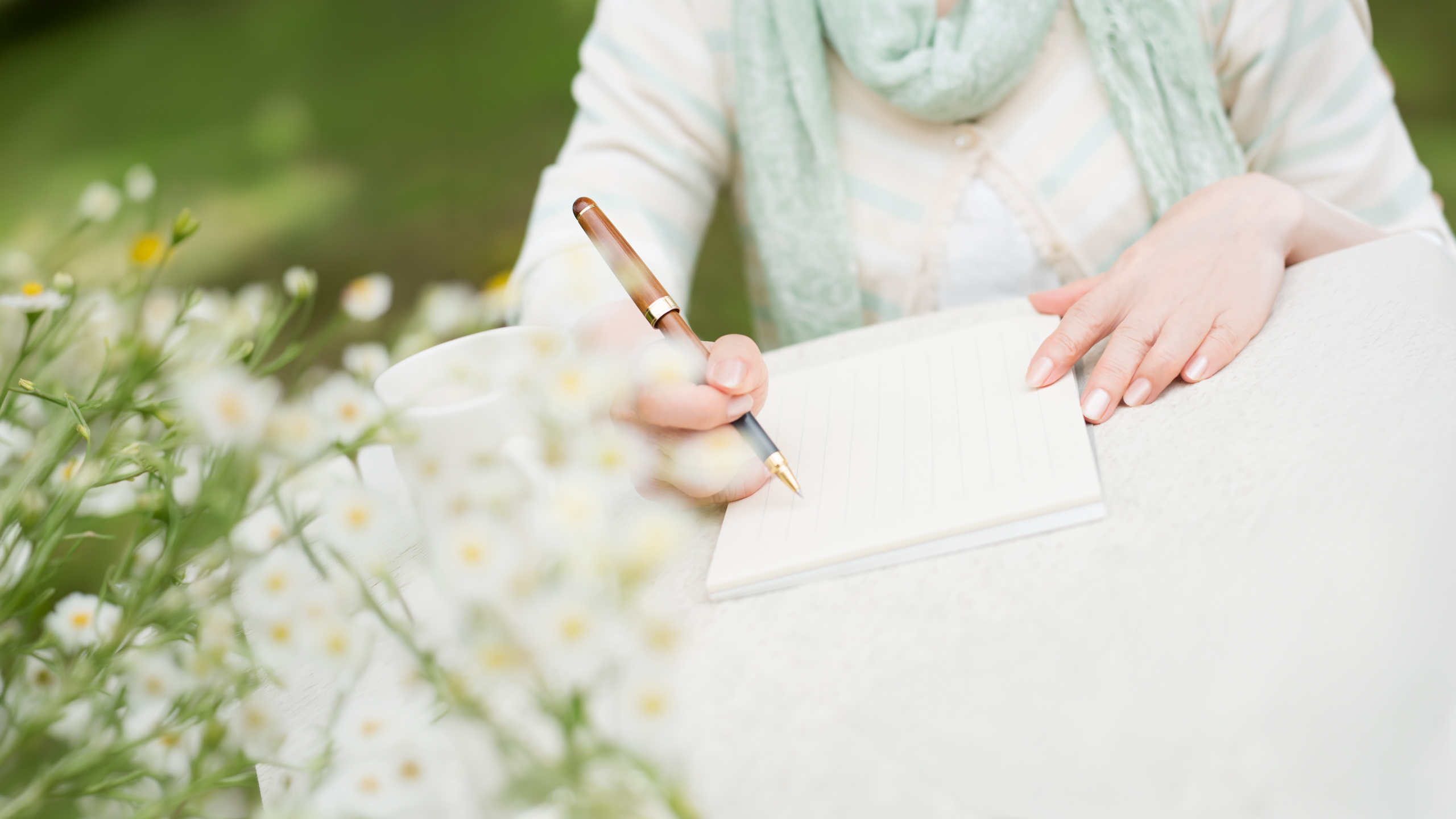 ノートにペンで書いている手元